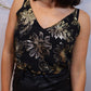 "Top à bretelles noires orné de motifs fleurs dorés : élégance florale. Ce top séduisant mêle le charme sobre des bretelles noires à l'éclat raffiné des motifs fleurs dorés. Une combinaison de sobriété et de glamour, parfaite pour illuminer votre tenue avec une touche de féminité sophistiquée."
